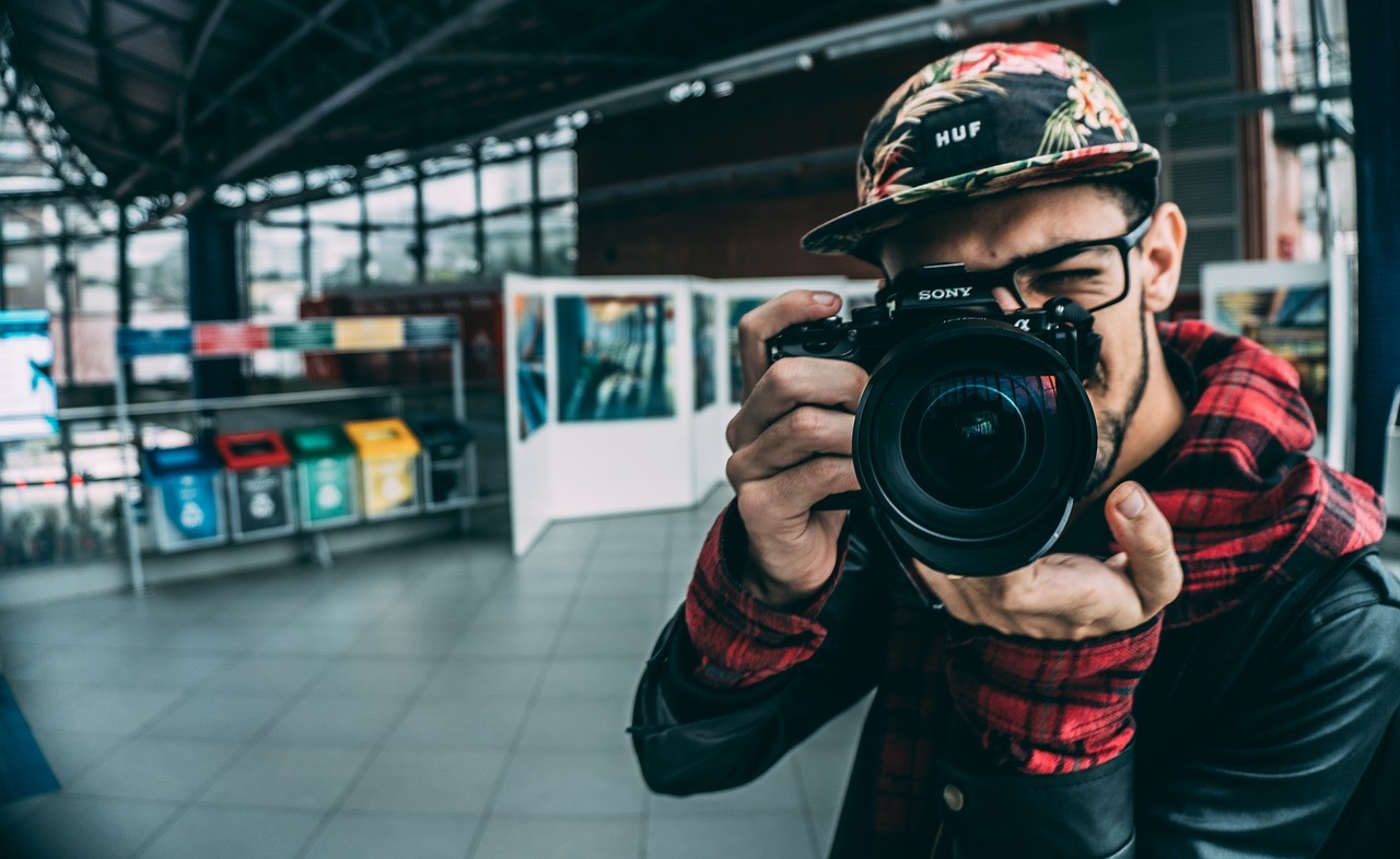 estudiante de curso de fotografía apuntando a cámara